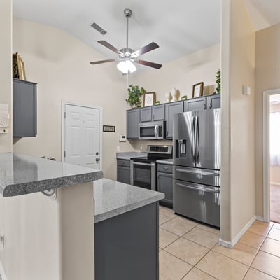 Open kitchen featuring breakfast bar, durable countertops, and included appliances ideal for casual meals and hosting.