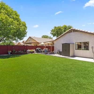 Large backyard with vibrant turf and landscaped borders, offering plenty of room for entertaining or recreation.