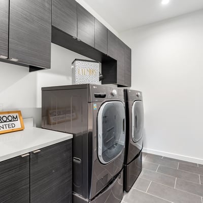 Functional laundry space with full-size appliances, built-in storage, and modern finishes, adding efficiency to everyday living in Phoenix.