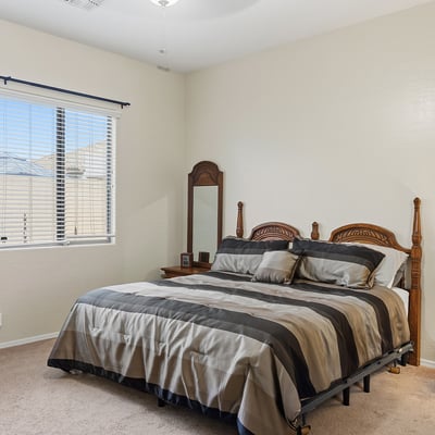 Inviting primary bedroom with large window, soft natural light, and neutral finishes, offering a peaceful retreat in this Phoenix home.