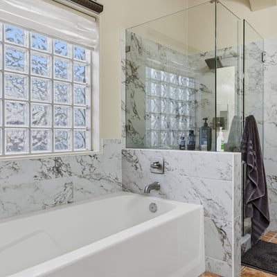 Primary bathroom with soaking tub, glass shower, and upgraded finishes, creating a relaxing and functional space in this Phoenix home.