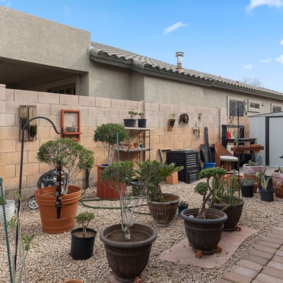 Generous side yard featuring artificial turf and desert landscaping, perfect for outdoor activities in this Phoenix home.