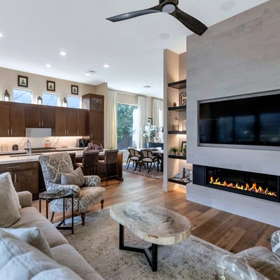 Open living area featuring a sleek fireplace, built-in shelving, and connection to the kitchen for easy entertaining in Phoenix.