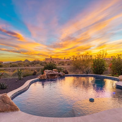 Tranquil pool setting surrounded by Scottsdale desert landscaping, highlighted by dramatic sunset colors and peaceful outdoor living spaces.