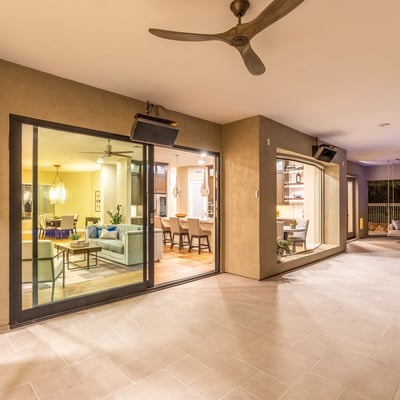 Expansive covered patio with tile flooring, ceiling fans, and sliding glass doors, creating a seamless transition between indoor comfort and Scottsdale outdoor living.