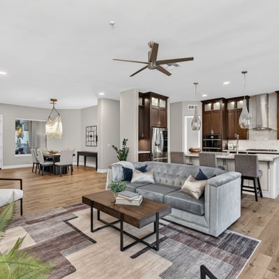Expansive open floor plan connecting living, dining, and kitchen areas with wood flooring and modern design, ideal for Scottsdale entertaining.
