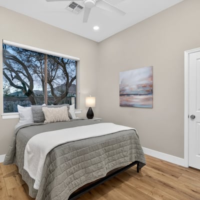 Peaceful Scottsdale bedroom with expansive window views, modern finishes, and wood flooring, ideal for relaxation.