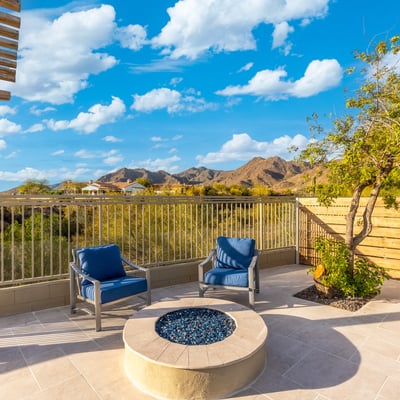 Cozy Scottsdale patio with fire pit and seating area overlooking scenic mountain views and desert landscape.