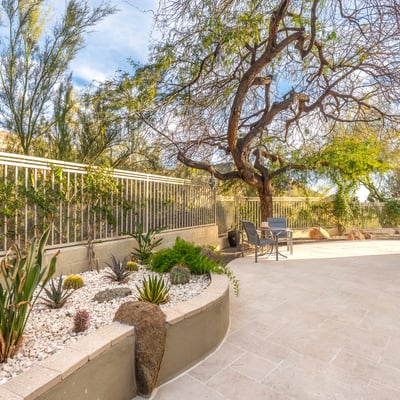 Scottsdale side yard with low-maintenance desert landscaping, stone accents, and paved walkway for easy upkeep.