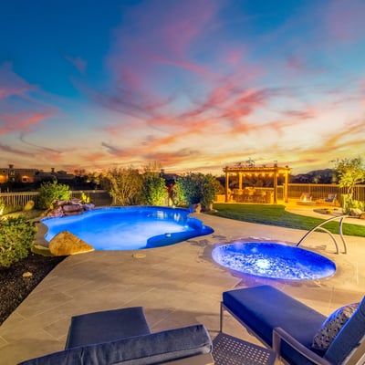 Scottsdale backyard with pool, pergola kitchen, fire pit, and sunset views, designed for upscale outdoor gatherings.