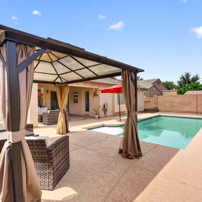 Backyard featuring a private pool and shaded pergola lounge area. Ideal for entertaining and enjoying warm Casa Grande evenings.