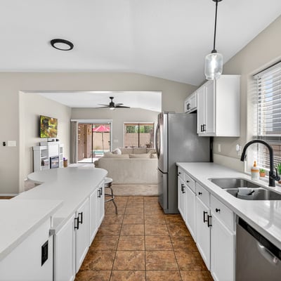 Well-designed kitchen with ample cabinets, stainless appliances, and extended counters. Open flow enhances functionality in this Casa Grande property.
