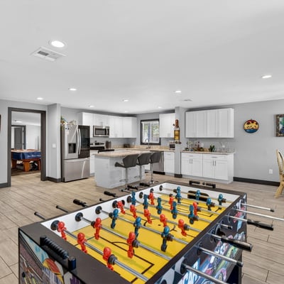 Versatile space combining game area and kitchen access, ideal for entertaining and flexible living arrangements.