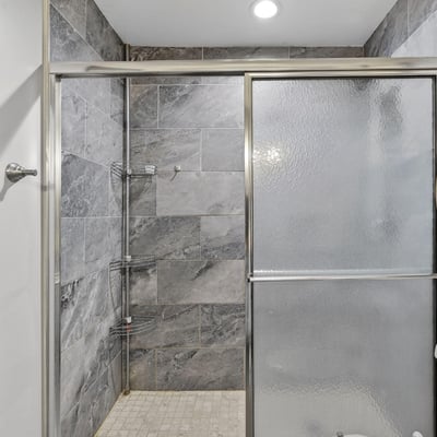 Contemporary walk-in shower with glass enclosure and upgraded tile, enhancing the home's modern appeal.
