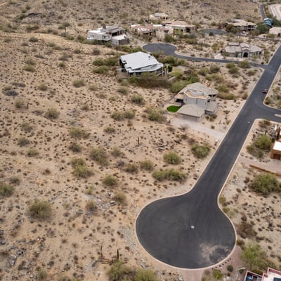 Expansive aerial view of this premium hillside lot surrounded by custom homes and breathtaking desert scenery. An ideal Phoenix location for building a luxury residence with mountain views.