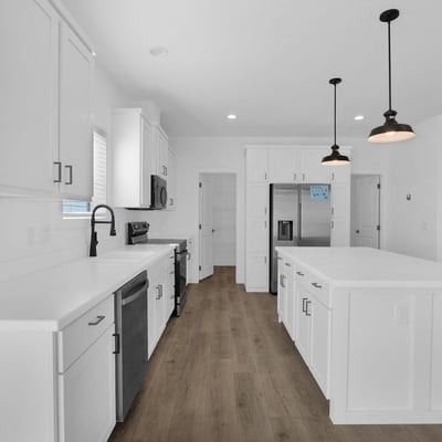 Modern kitchen showcasing an oversized island, stainless steel appliances, shaker cabinetry, and extensive workspace. Ideal for meal preparation, entertaining, and enjoying the heart of this beautifully designed home.