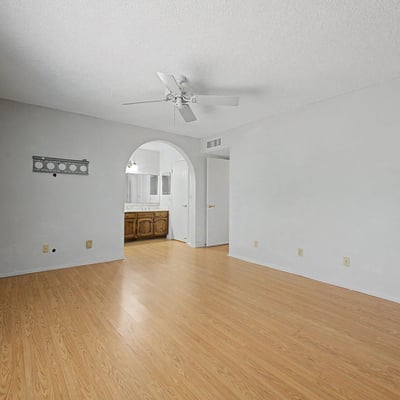 This large primary suite offers a comfortable setting with natural light, a ceiling fan, and direct access to the ensuite bath. The open layout creates a relaxing environment perfect for everyday living.