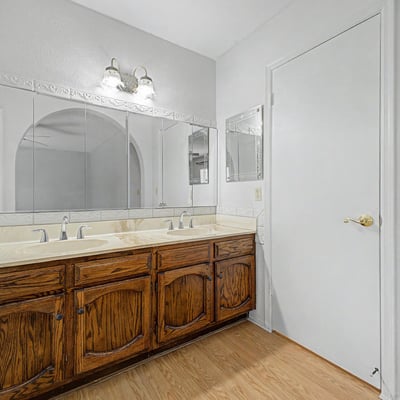 The bathroom's dual-sink vanity provides extensive storage, generous countertop space, and large mirrors for added convenience. Thoughtful design elements support both functionality and everyday comfort.
