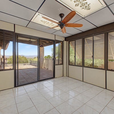Large windows and tile flooring define this bright Arizona room, creating a comfortable extension of the home's living space. Perfect for entertaining, reading, or enjoying views of the surrounding landscape.