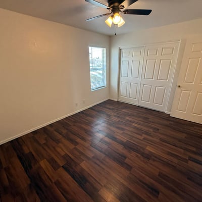 Spacious bedroom featuring a large closet, neutral finishes, and durable flooring. The room's generous proportions create a comfortable setting for a variety of furniture configurations.