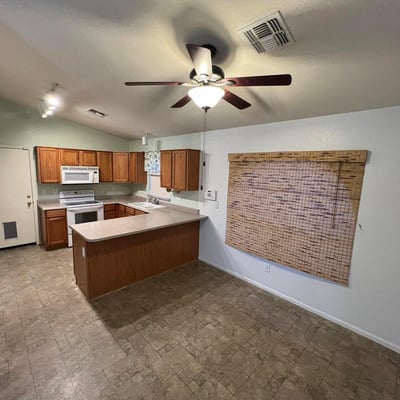 Functional kitchen featuring extensive cabinetry, a breakfast bar peninsula, and adjacent dining space. The thoughtful design allows easy interaction with guests while preparing meals.