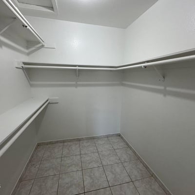 Generously sized walk-in closet featuring extensive hanging space, shelving, and room for organized storage. Ideal for keeping wardrobes and personal items neatly arranged.