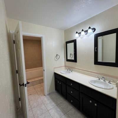 Well-appointed bathroom showcasing a double vanity, updated fixtures, abundant counter space, and tile flooring. Designed for everyday convenience, this space supports busy households and visiting guests alike.