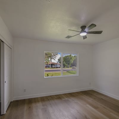 Freshly updated with modern flooring, neutral finishes, and a ceiling fan, this spacious bedroom easily adapts to guests, family, or a productive home office.