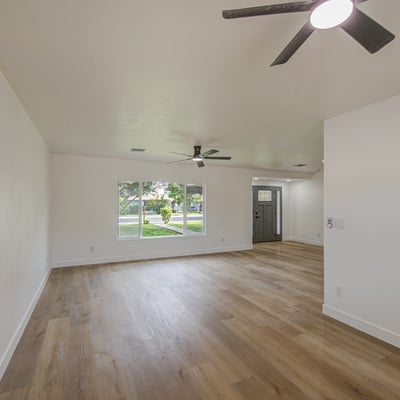 Large picture windows brighten this inviting living room, highlighting the home's modern flooring, fresh interior updates, and comfortable open-concept design.