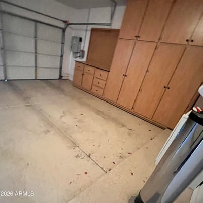 Two-car garage with extensive custom storage cabinets, built-in work area, and generous space for vehicles, tools, and recreational equipment, making organization simple and efficient.