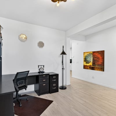 This dedicated office provides an ideal work-from-home environment with durable wood-look tile flooring, generous natural light, and versatile space for business or hobbies.