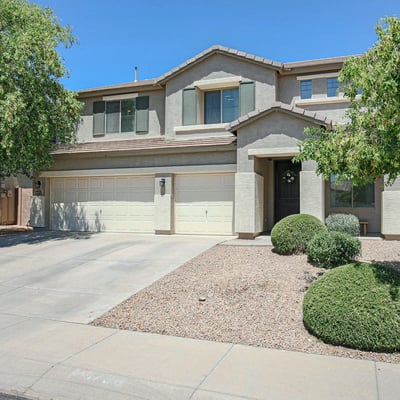 Well-maintained front exterior highlighting mature landscaping, covered entrance, and a spacious 3-car garage. This beautiful Waddell home offers lasting curb appeal.