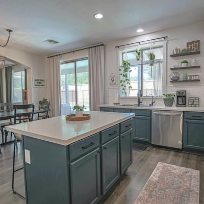 Beautifully updated kitchen featuring abundant cabinetry, quartz countertops, stainless steel appliances, and an open layout connecting effortlessly to the dining room and outdoor living areas.