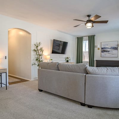 Spacious family room featuring a dedicated workspace, custom media wall, and comfortable seating area. This versatile room adapts easily to work, entertainment, and everyday living.