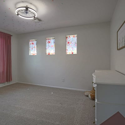 Bright secondary bedroom with plush carpeting, large windows, and flexible space for guests, children, or a dedicated home office in this move-in-ready Waddell property.
