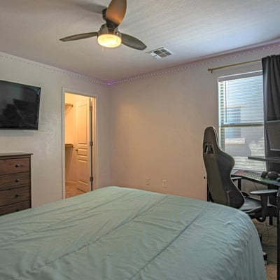 Spacious bedroom featuring soft carpeting, ceiling fan, and abundant natural light. This flexible room adapts easily as a guest room, teen suite, or dedicated workspace.