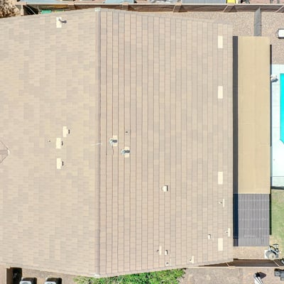 Bird's-eye view showcasing the property's backyard with a sparkling pool, covered patio, lawn area, and low-maintenance landscaping. An excellent aerial perspective of this Waddell home's outdoor amenities.