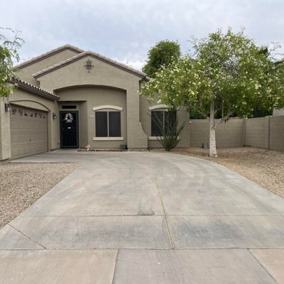Angled view of the home's exterior highlighting the spacious driveway, RV gate, mature landscaping, and inviting architectural design that enhances this Canyon Trails property