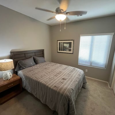 Bright secondary bedroom with neutral finishes, plush carpeting, ceiling fan, and closet space, providing flexibility for a guest room, nursery, or home office.