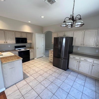 Designed for convenience, this spacious kitchen offers abundant cabinetry, extensive counter space, tile floors, pantry storage, and a bright dining area for casual meals.