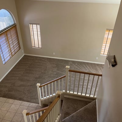 From the upper level, enjoy a striking view of the dramatic foyer featuring vaulted ceilings, expansive windows, and a spacious open-concept design.