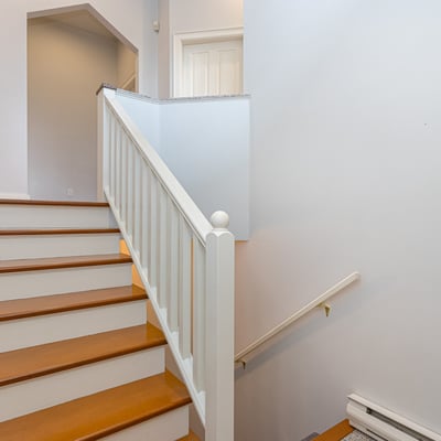 This inviting staircase features wooden steps and natural light, leading to additional living spaces upstairs.