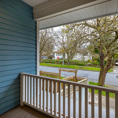 Enjoy morning coffee on this inviting porch overlooking a tree-lined street in a peaceful neighborhood.