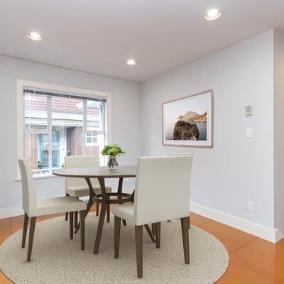 Bright and airy dining area featuring a modern table set and large windows for natural light.