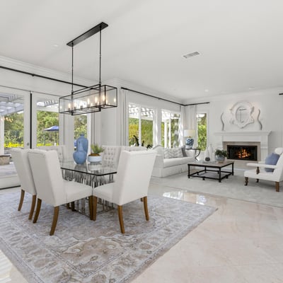 Bright and spacious living area with large windows, a cozy fireplace, and a seamless outdoor connection.