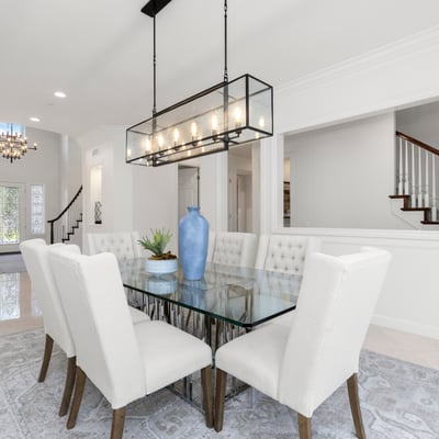 Bright and airy dining area, featuring a modern glass table and plush seating, perfect for gatherings.