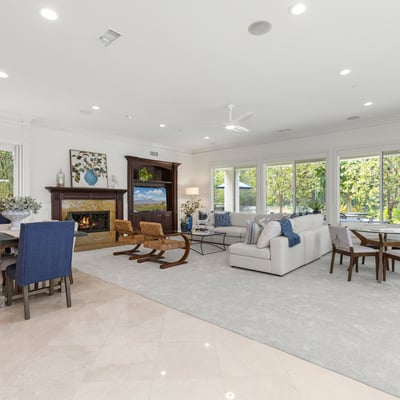 flooded with abundant natural light, showcasing a cozy fireplace and open connectivity to dining spaces.
