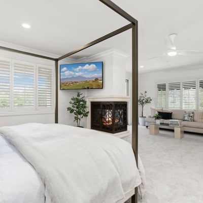 Primary Bedroom -Spacious bedroom with a cozy fireplace, adjacent sitting area, and abundant natural light throughout. (TV Included)