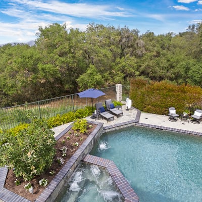 Primary Bedroom Balcony- Discover a private oasis with a refreshing pool, lush greenery, and inviting outdoor seating for relaxation.