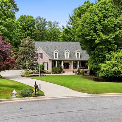 Beautifully landscaped home nestled on a quiet cul-de-sac, surrounded by mature trees and vibrant foliage.